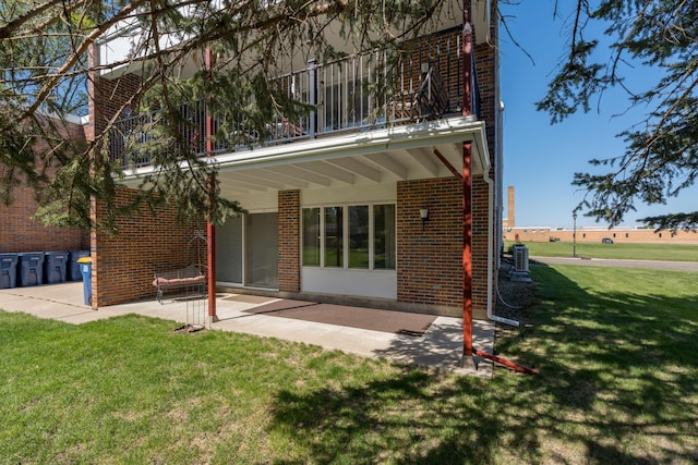 529 Spring St Unit 4, Kenyon, MN 55946 - rear view of house with a patio area, a yard, brick siding, and a balcony