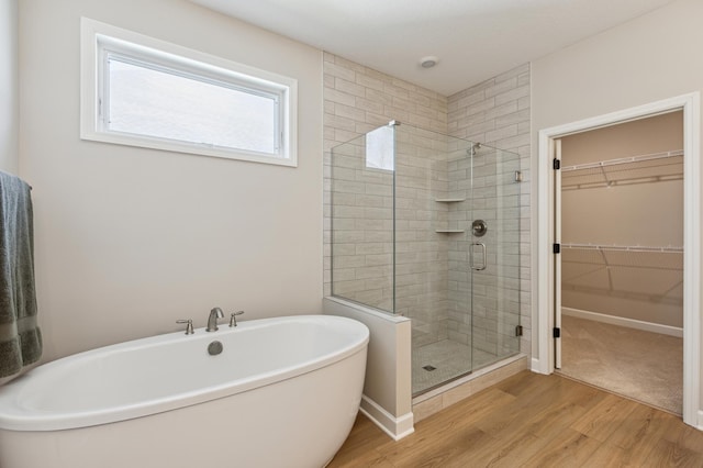 8014 Walnut Ln, Corcoran, MN 55340 - full bath featuring a shower stall, a soaking tub, a walk in closet, and wood finished floors