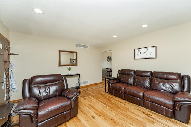 living room featuring light wood finished floors, baseboards, and recessed lighting