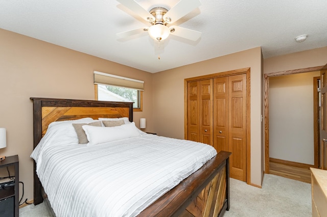 bedroom with a closet, light carpet, and a ceiling fan