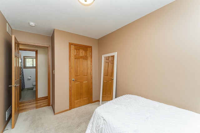 bedroom featuring light colored carpet, a closet, and baseboards