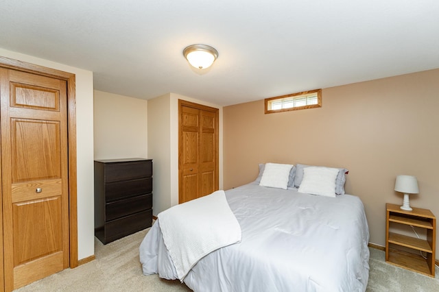 bedroom featuring light carpet, a closet, and baseboards