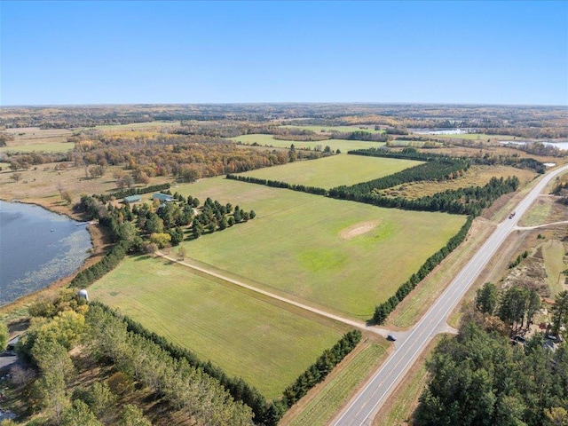 aerial view of property and surrounding area featuring rural landscape and a large body of water