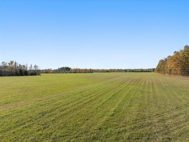 view of green lawn featuring a view of countryside