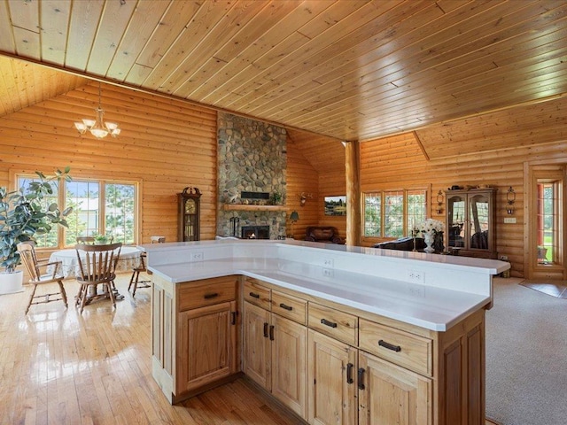 kitchen featuring open floor plan, wood ceiling, plenty of natural light, log walls, and a stone fireplace