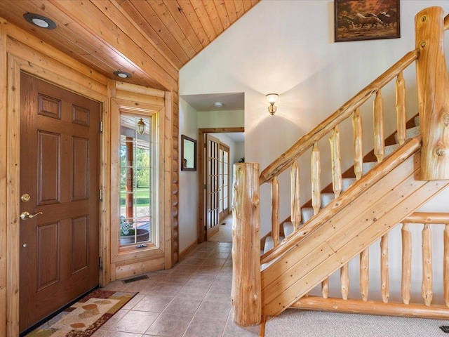 tiled foyer with wooden ceiling, stairs, and lofted ceiling