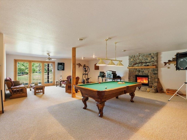 playroom featuring carpet floors, billiards, a fireplace, a ceiling fan, and a textured ceiling