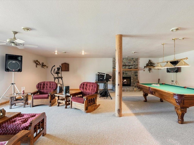rec room featuring carpet floors, a stone fireplace, billiards, a textured ceiling, and ceiling fan