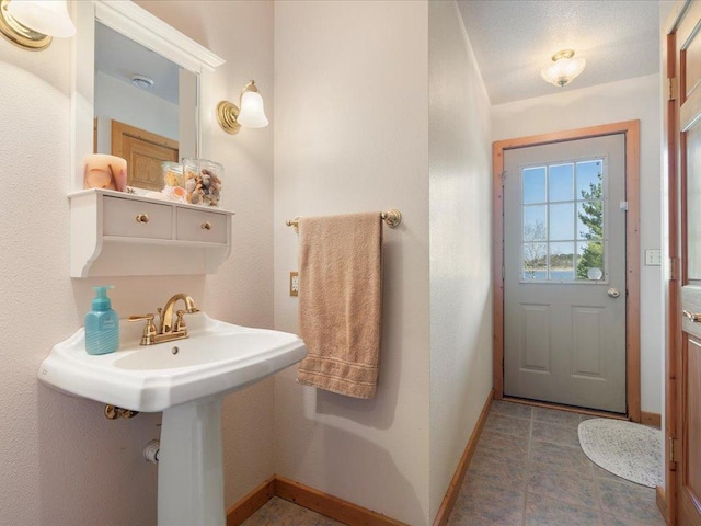 bathroom featuring baseboards and a sink