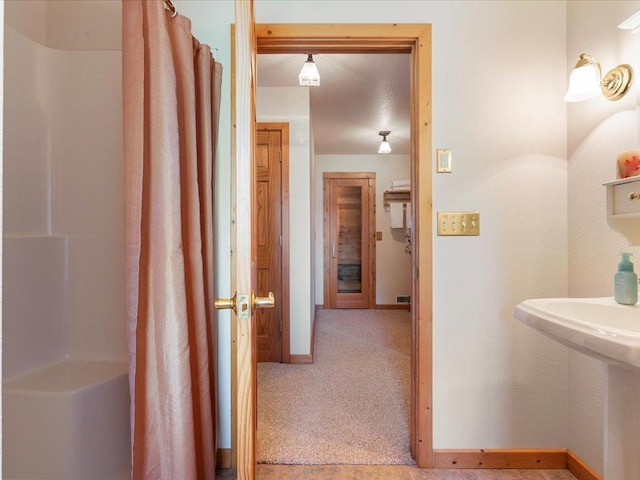 full bathroom with baseboards, curtained shower, and a sink
