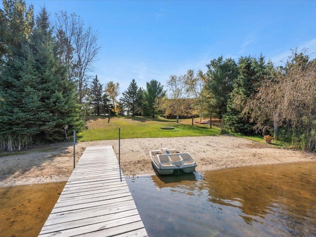 dock featuring a yard and view of wooded area