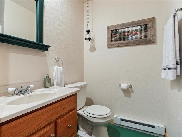 bathroom featuring a baseboard heating unit, toilet, and vanity