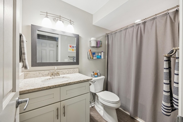 bathroom with wood finished floors, toilet, vanity, and a shower with shower curtain