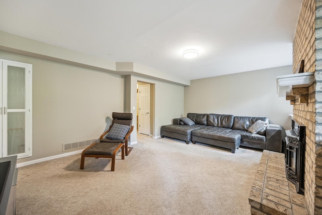 carpeted living area with a brick fireplace and baseboards