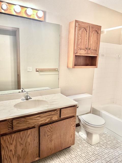 bathroom with toilet, vanity, and shower / bathtub combination