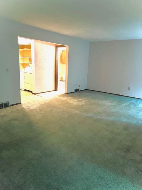 unfurnished room with light carpet and washer / dryer