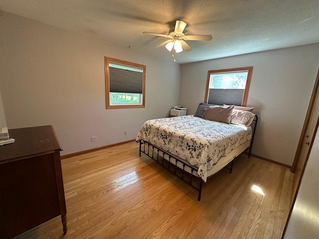 4220 23rd St NW, Willmar, MN 56201 - bedroom featuring light wood finished floors, baseboards, ceiling fan, and a textured ceiling