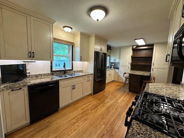 4220 23rd St NW, Willmar, MN 56201 - kitchen featuring black appliances, a sink, open shelves, light wood-style floors, and a textured ceiling