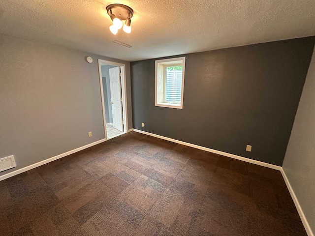 4220 23rd St NW, Willmar, MN 56201 - empty room featuring a textured ceiling, a smoke detector, baseboards, and dark colored carpet