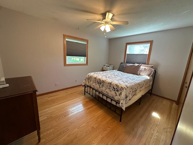 4220 23rd St NW, Willmar, MN 56201 - bedroom with light wood finished floors, baseboards, a ceiling fan, and a textured ceiling