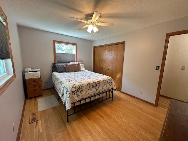 4220 23rd St NW, Willmar, MN 56201 - bedroom featuring light wood-style floors, a closet, ceiling fan, baseboards, and a textured ceiling