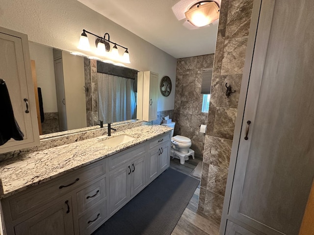 4220 23rd St NW, Willmar, MN 56201 - bathroom with tiled shower, vanity, toilet, and tile walls