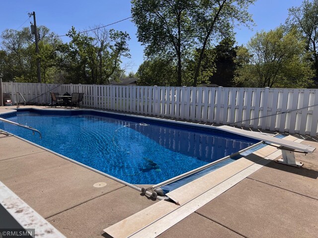 404 Clayborn Ave, Parkers Prairie, MN 56361 - view of swimming pool featuring a patio area, a fenced backyard, and a diving board