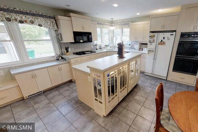 404 Clayborn Ave, Parkers Prairie, MN 56361 - kitchen featuring black appliances, decorative backsplash, light countertops, a sink, and recessed lighting