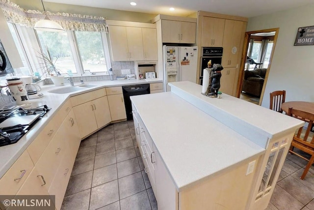 404 Clayborn Ave, Parkers Prairie, MN 56361 - kitchen featuring a sink, black appliances, a center island, recessed lighting, and light tile patterned floors