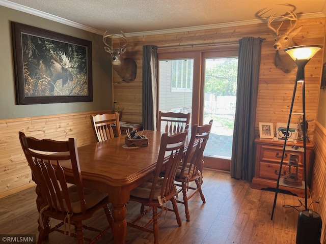 404 Clayborn Ave, Parkers Prairie, MN 56361 - dining area featuring wood walls, crown molding, hardwood / wood-style floors, and a textured ceiling