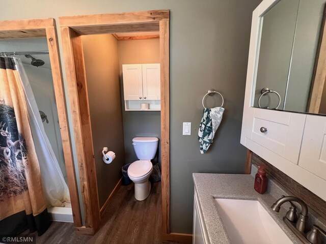 404 Clayborn Ave, Parkers Prairie, MN 56361 - full bathroom featuring wood finished floors, curtained shower, toilet, vanity, and baseboards