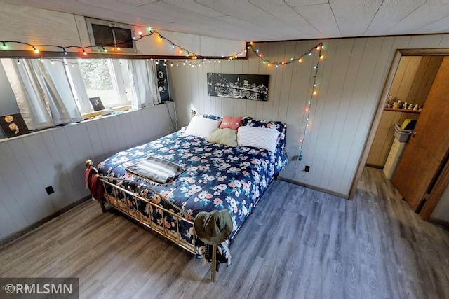 404 Clayborn Ave, Parkers Prairie, MN 56361 - bedroom with wood finished floors and wooden walls