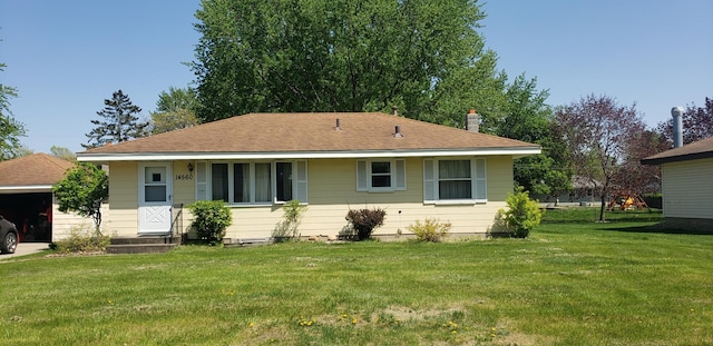 rear view of house with a lawn and a shingled roof