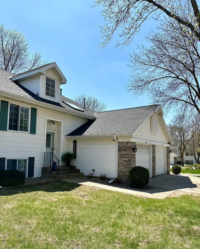 view of front of house featuring concrete driveway, a front yard, a shingled roof, an attached garage, and brick siding
