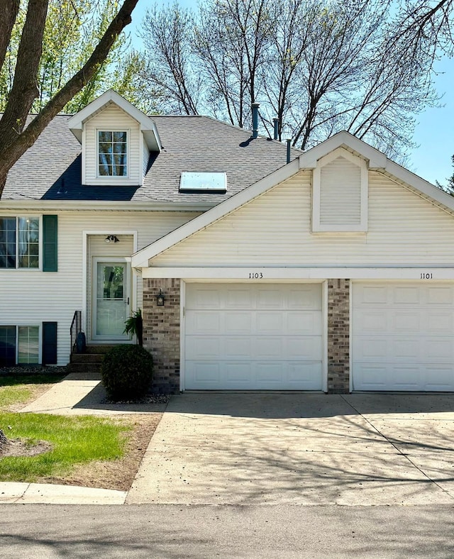 view of front of home featuring brick siding, driveway, and an attached garage