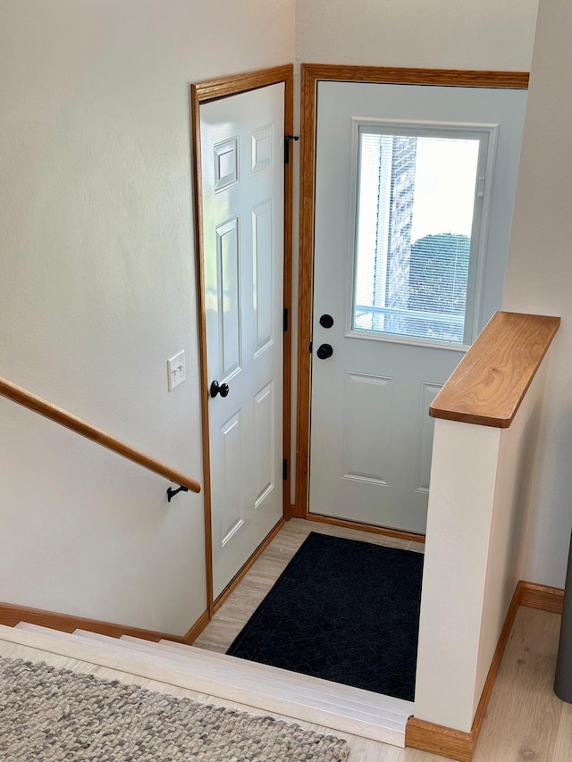 entryway with baseboards and light wood finished floors
