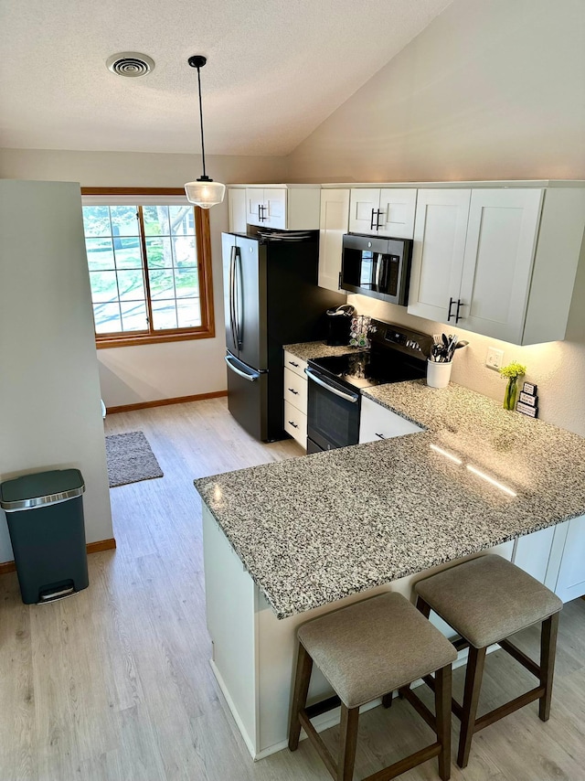 kitchen with stainless steel appliances, light stone countertops, light wood-type flooring, white cabinetry, and baseboards