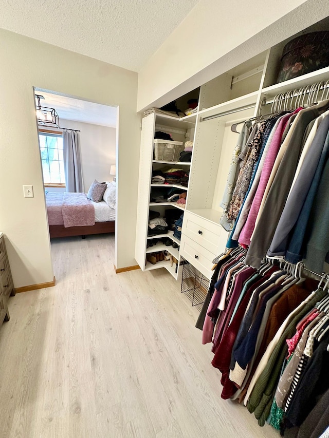 walk in closet with wood finished floors