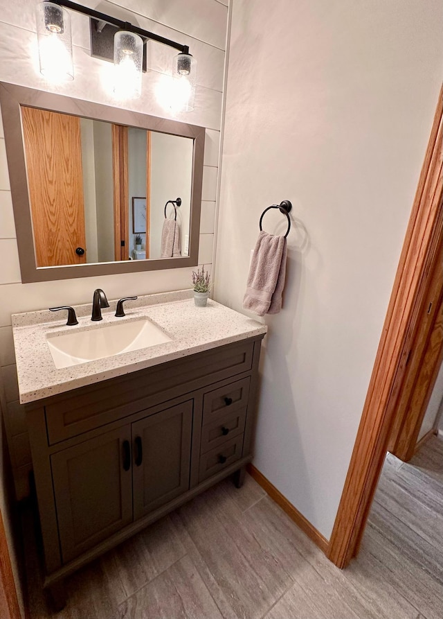 bathroom featuring wood finished floors, vanity, and baseboards