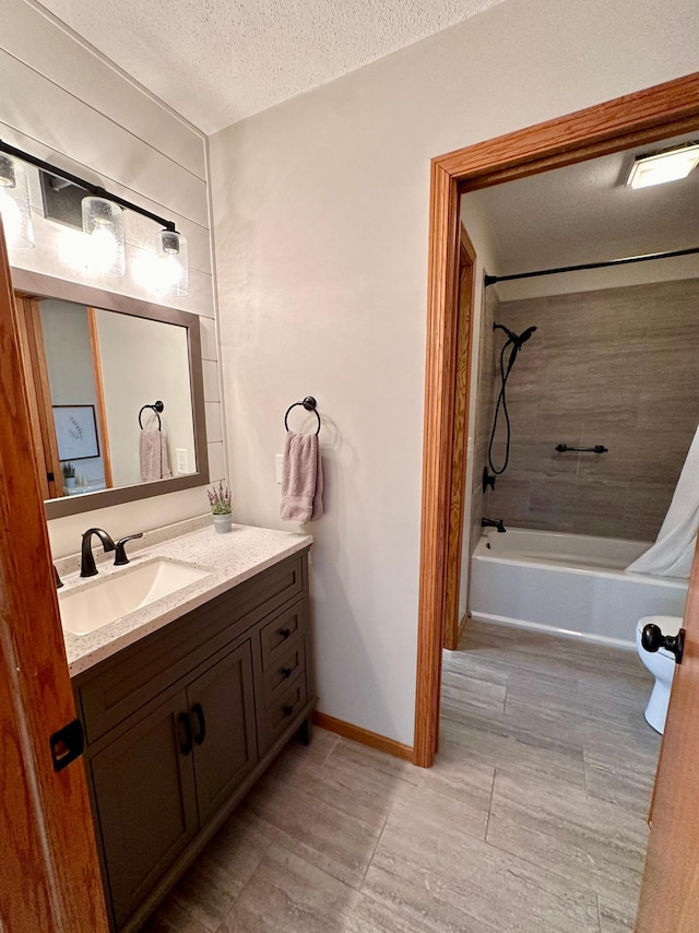 bathroom featuring a textured ceiling, vanity, and shower / washtub combination