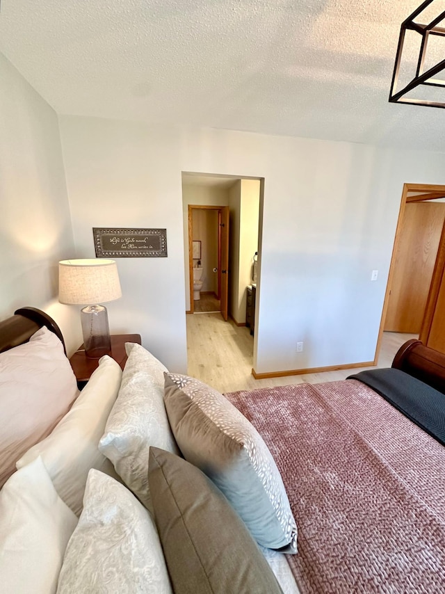 bedroom featuring a textured ceiling and light wood-type flooring