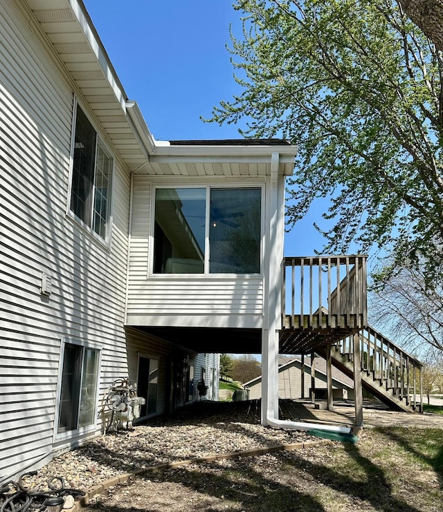 view of property exterior with stairs and a wooden deck