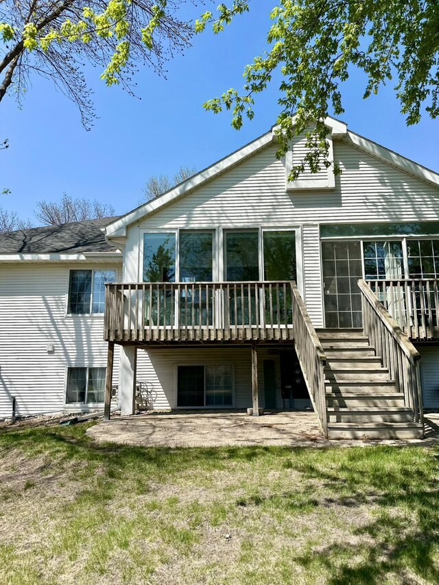 back of house featuring stairs, a deck, a patio area, and a yard
