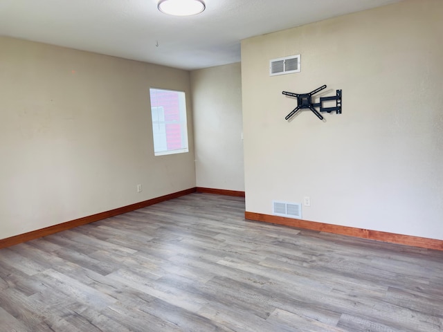 empty room with baseboards and wood finished floors