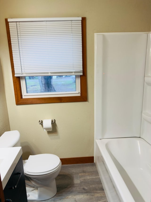 full bathroom with wood finished floors, baseboards, toilet, and vanity