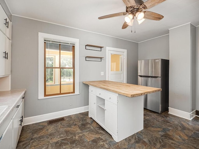 5844 Stagecoach Trl N, Oak Park Heights, MN 55082 - kitchen featuring freestanding refrigerator, butcher block counters, open shelves, ornamental molding, and dark stone finish floors