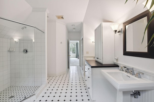 full bathroom featuring a stall shower, crown molding, tile patterned floors, and a sink