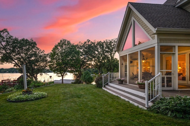 view of grassy yard with a sunroom