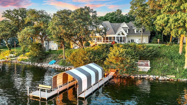 dock area with a water view and view of wooded area