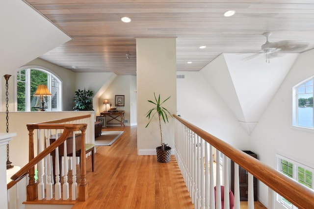 corridor with light wood-type flooring, an upstairs landing, recessed lighting, and baseboards